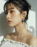 Sparkling Made petite blue shimmer butterfly pearl earrings worn by model, lightweight and elegant for everyday wear