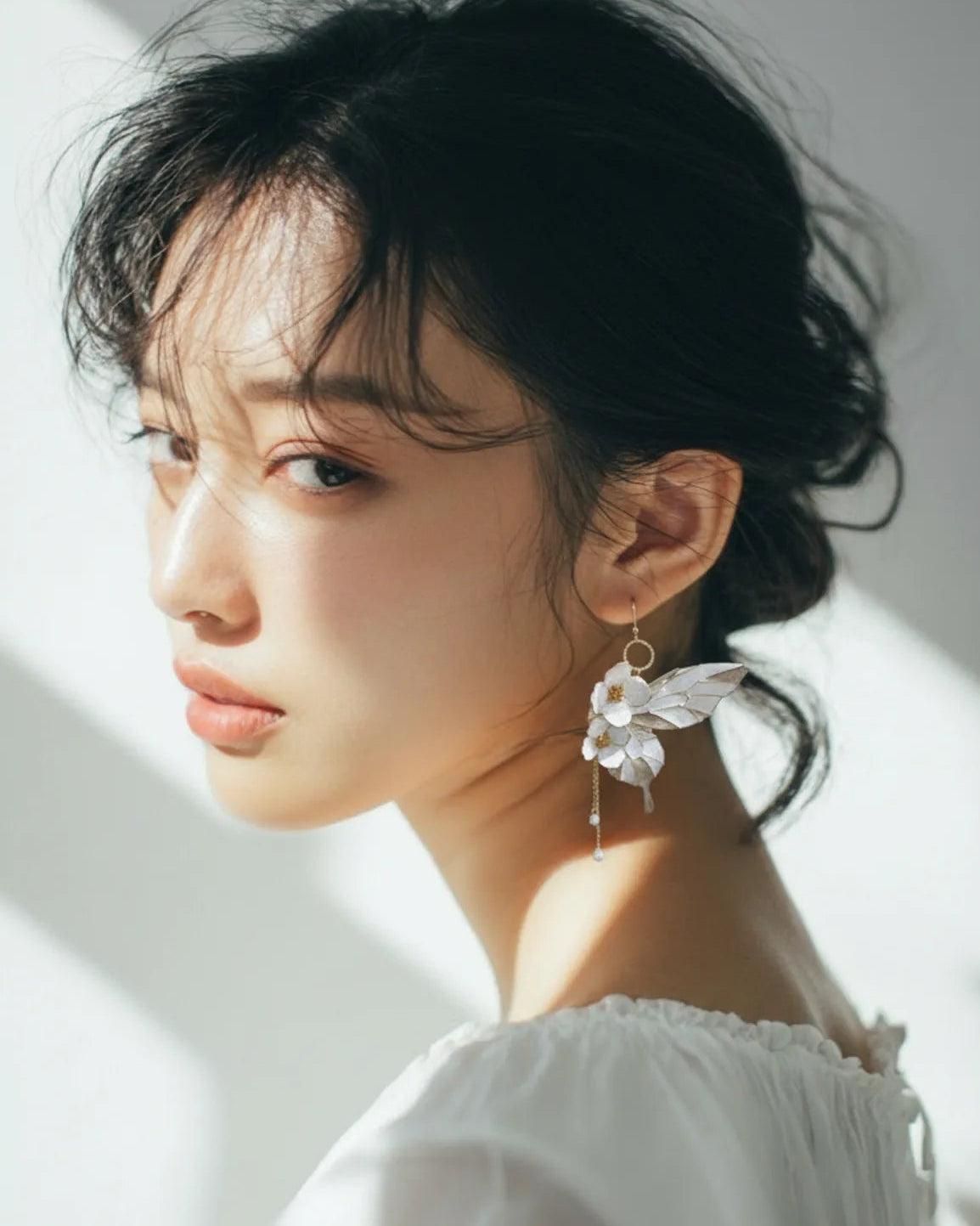 Sparkling Made flower butterfly earrings with pearl shine worn by model, artistic statement style with soft movement