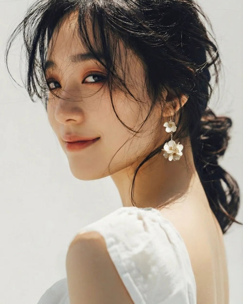 Sparkling Made petite flower dangle earrings with pearl shine worn by model, delicate and comfortable for daily styling